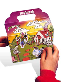 a child is holding a box with a picture of a house