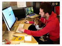 a man sitting at a desk with a dog